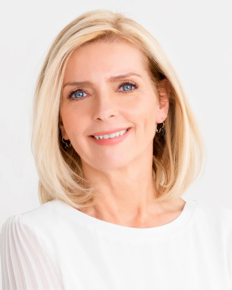 Mature woman with short blond hair wearing white blouse